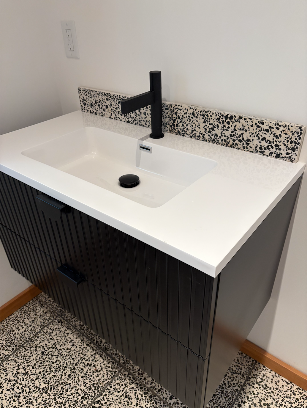 Custom bathroom vanity and terrazzo-style tile within the new primary suite