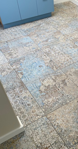Custom patterned tile flooring with blue cabinetry