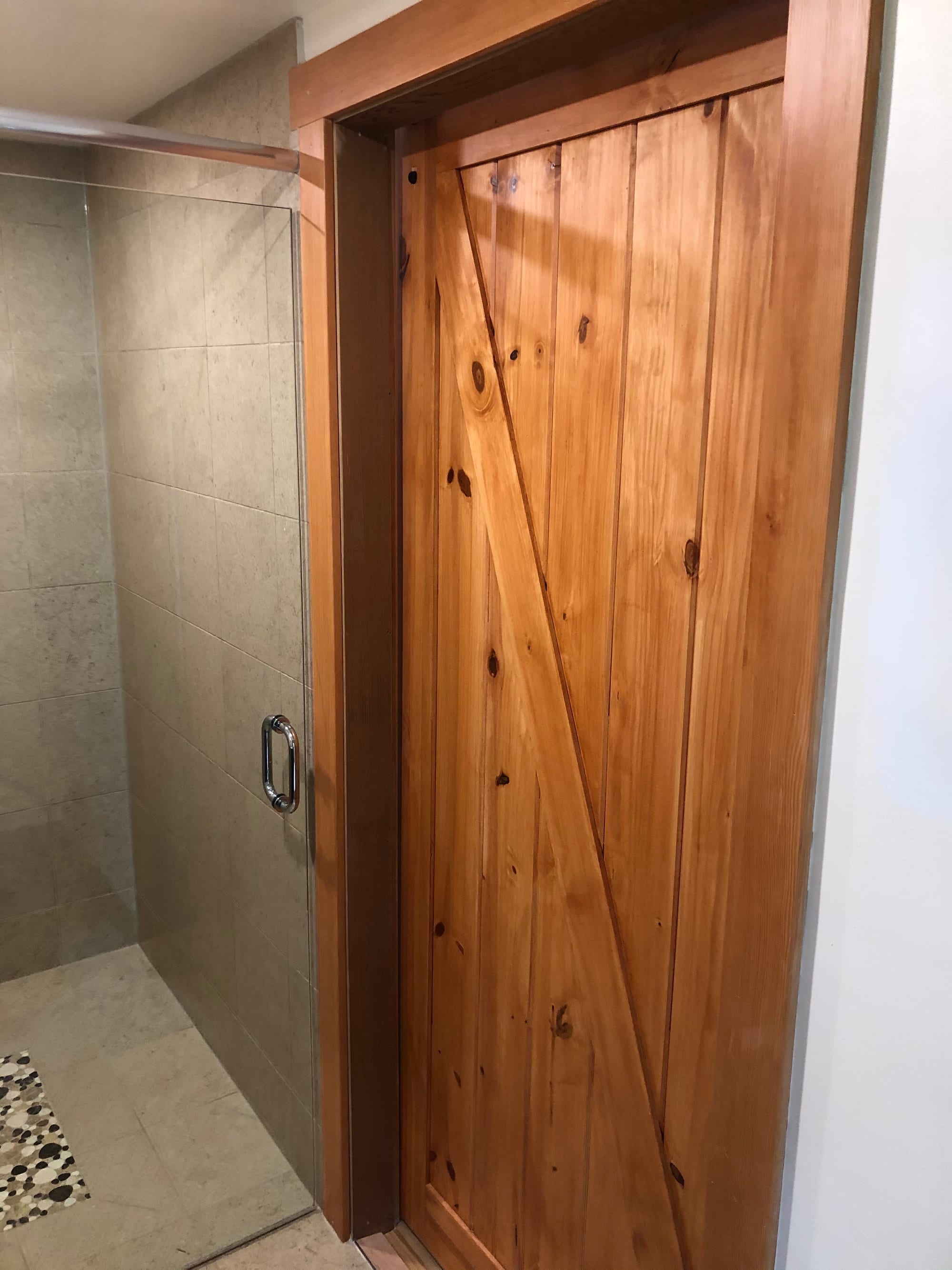 Guest ensuite — custom sliding wood door beside the shower
