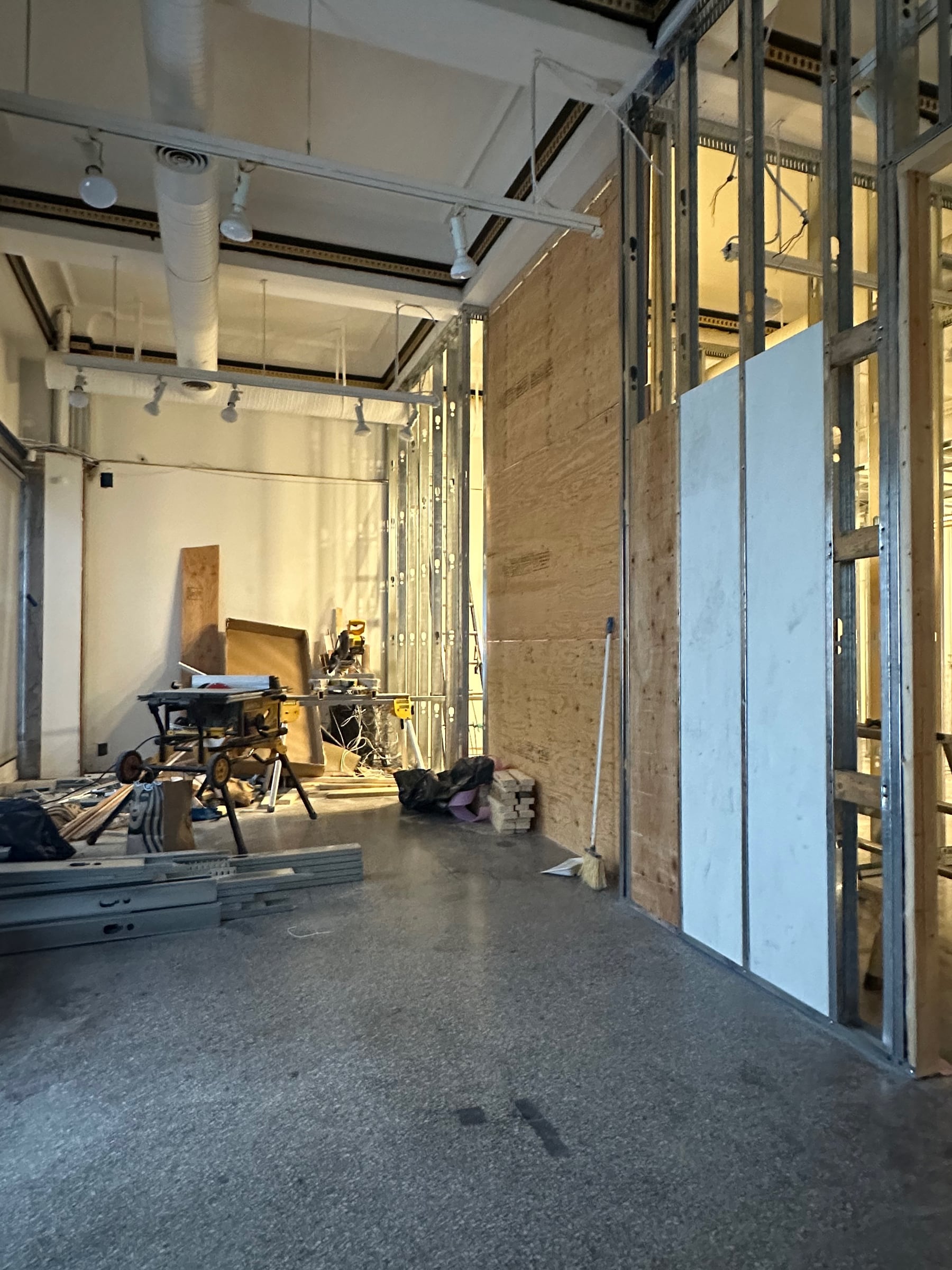 Existing commercial interior with new steel-stud framing and mechanical work during construction