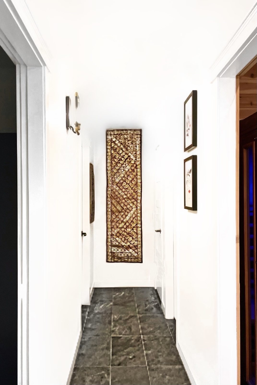 Narrow corridor with dark tile floor leading to sauna and specialized treatment areas