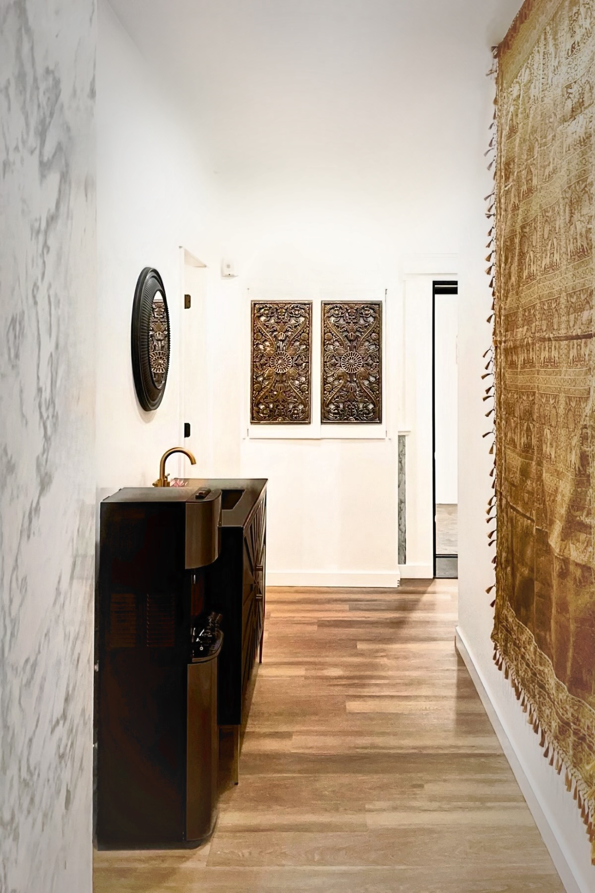 Corridor connecting treatment areas within the completed Broad Street commercial renovation — stone-look wall, water station and depth into the interior