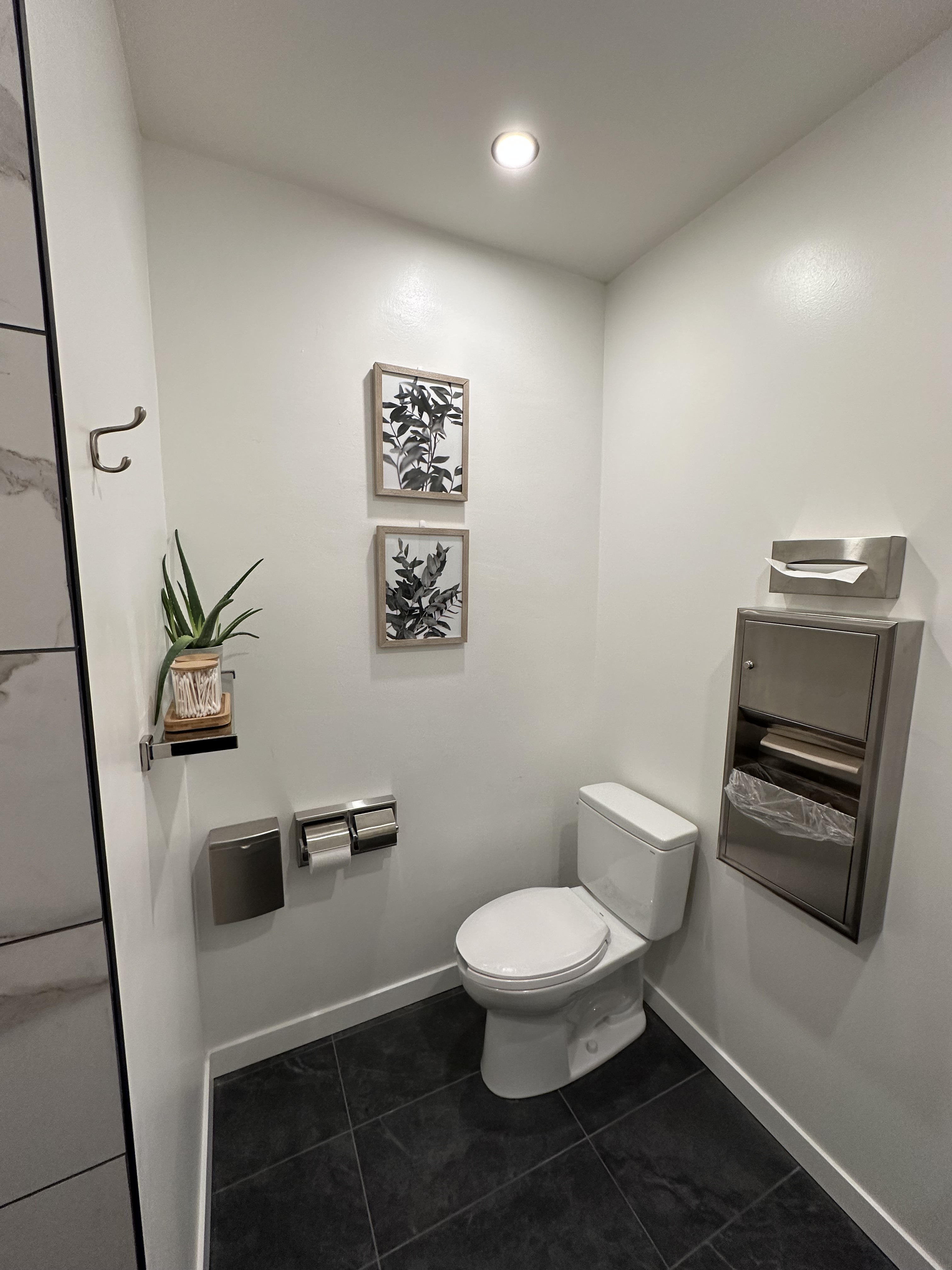 Completed public washroom with tiled floor and commercial paper dispensers