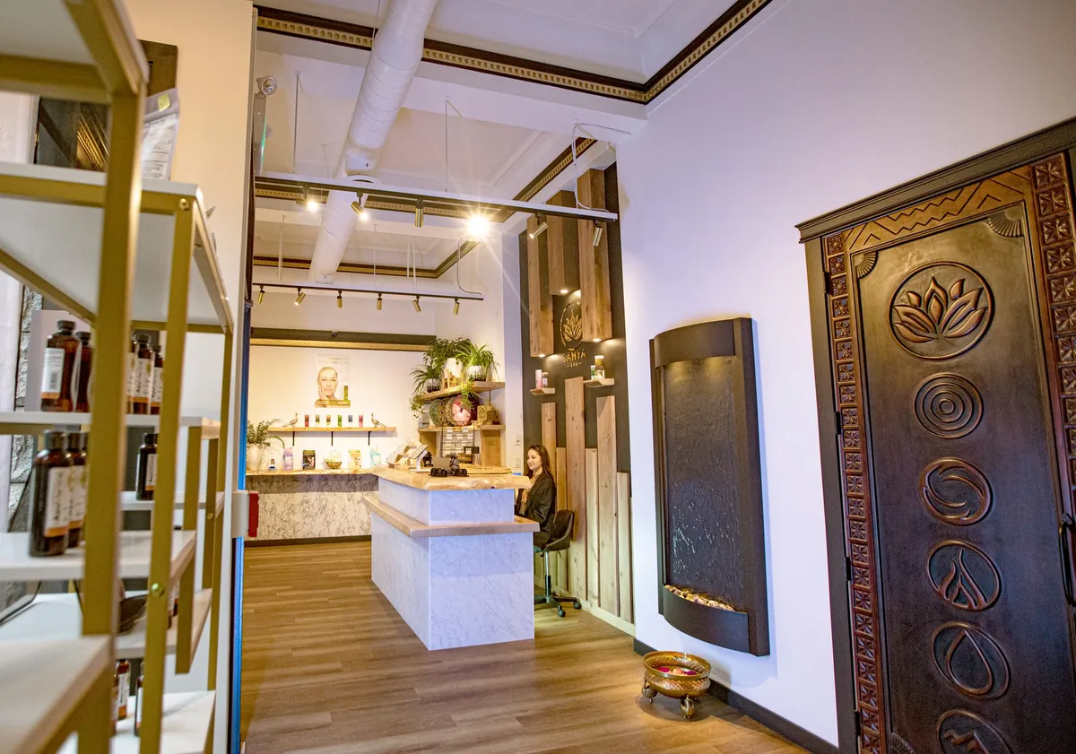 Completed Samya Spa reception and retail area with custom reception counter, carved decorative feature and water element