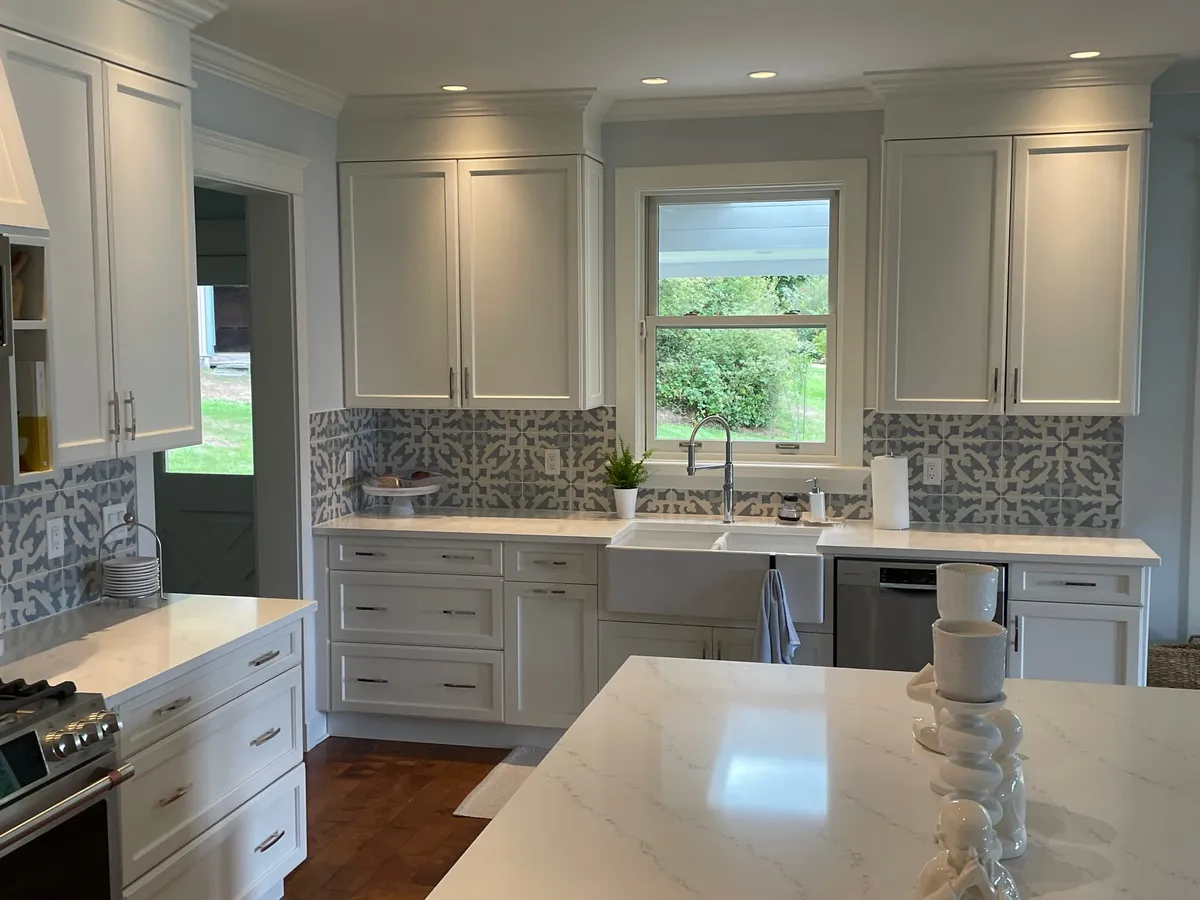 Interior renovation — completed kitchen with white cabinetry and patterned tile backsplash