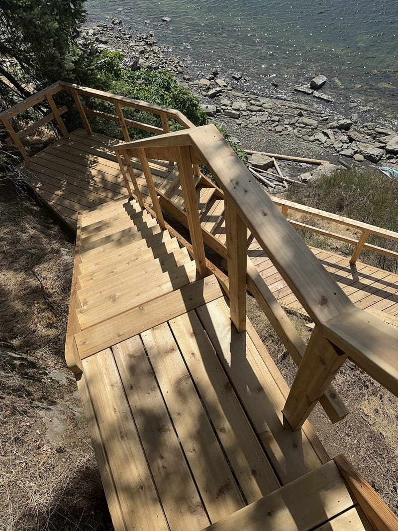 Cedar stair and walkway system descending a steep coastal slope to the shoreline