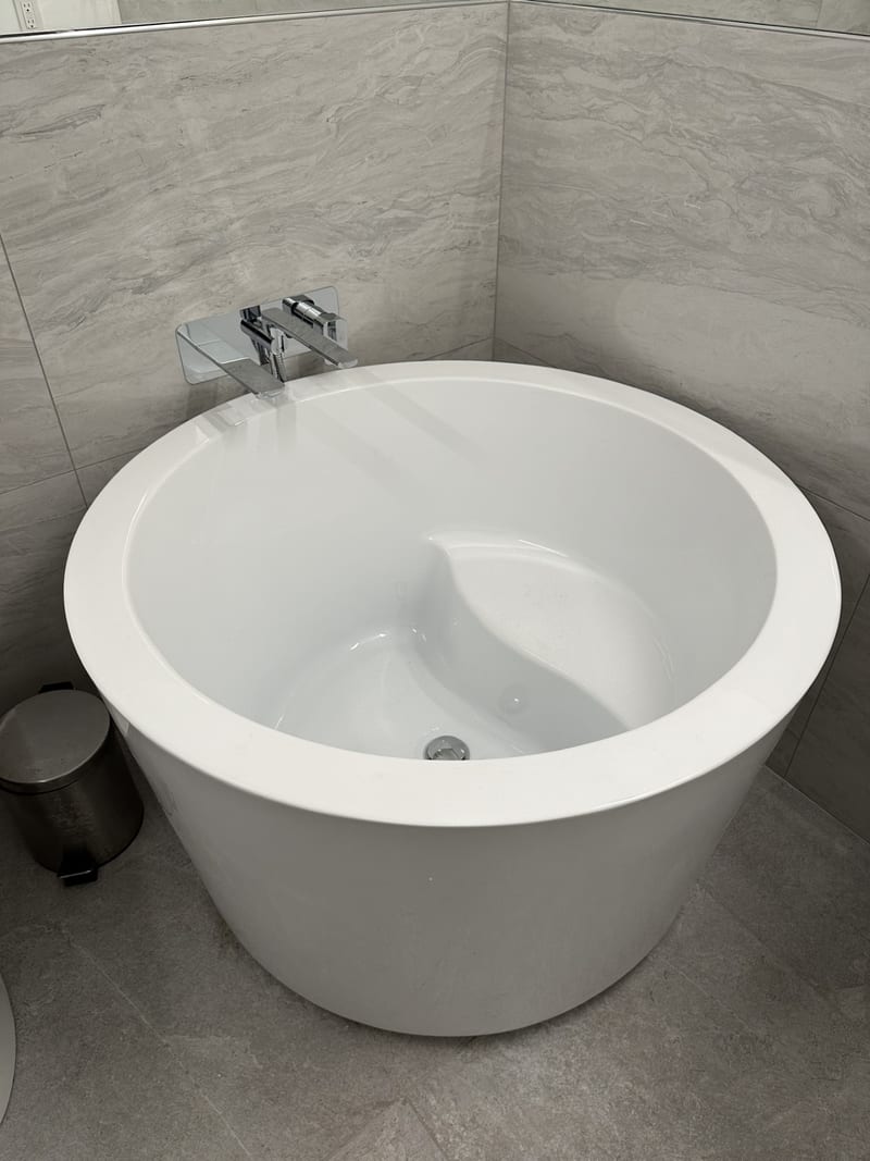 Finished bathroom interior with tiled shower and freestanding tub