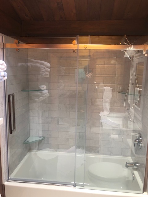 Finished heritage-era home bathroom with glass-enclosed tub and shower