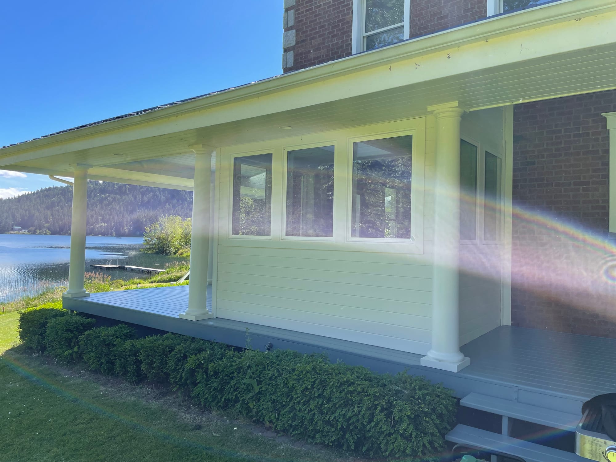 Character home addition and covered porch beside the lake