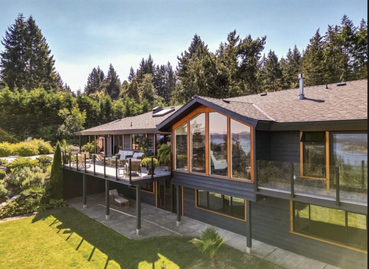 Ocean view estate — completed exterior with dark siding, cedar-trimmed glazing and ocean outlook